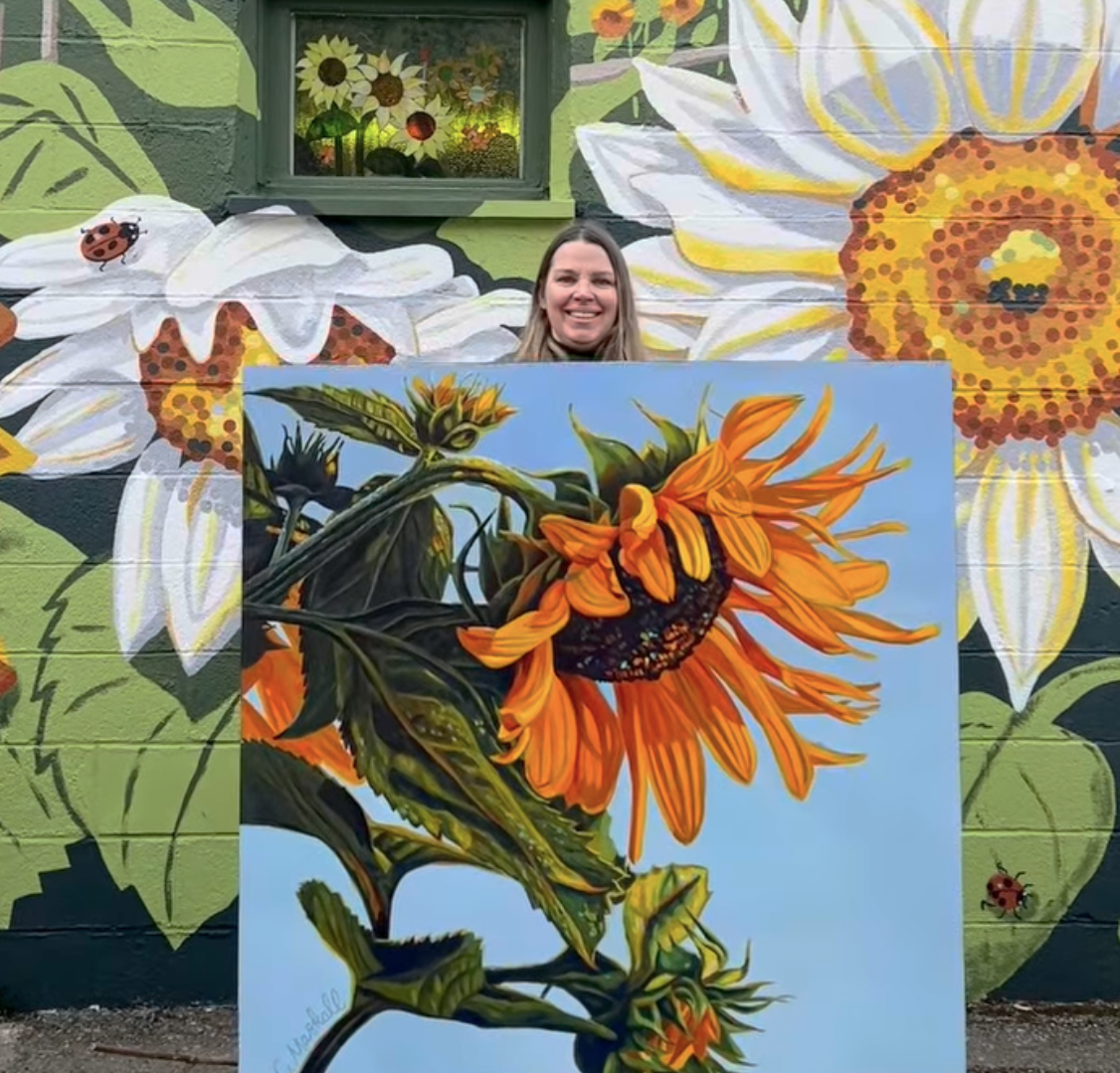 Painter and illustrator Carla Maskell with sunflower painting and mural